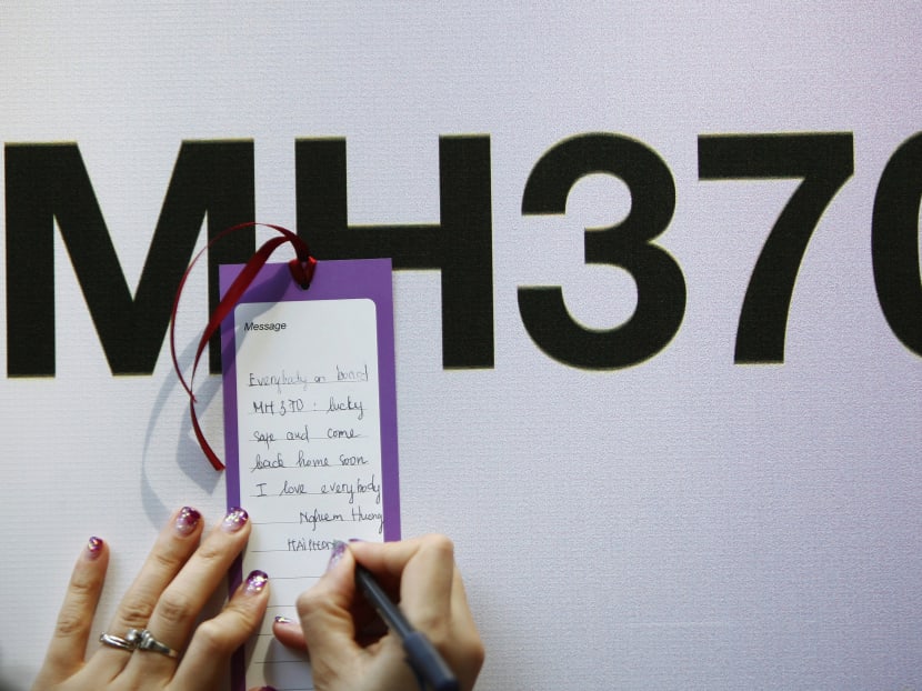 A tourist from Vietnam writes a message expressing hope for family members and those onboard the missing Malaysia Airlines flight MH370. Photo: REUTERS