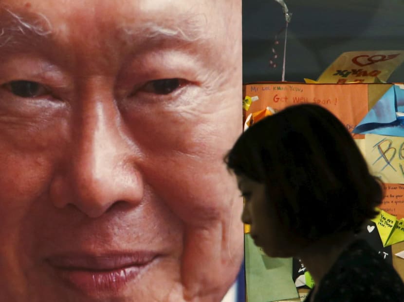 A woman passes a picture of former Singaporean prime minister Lee Kuan Yew, placed at the Singapore General Hospital. Photo: Reuters