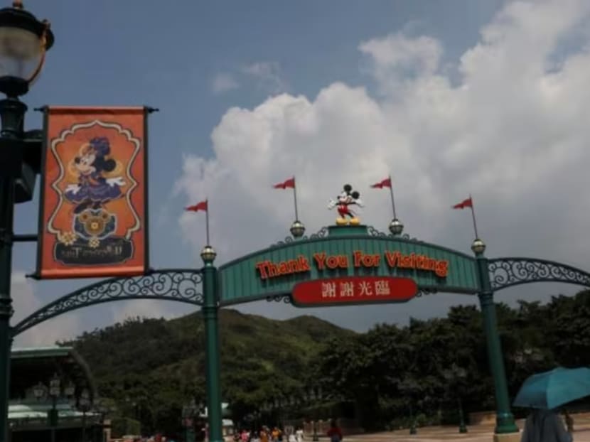 Visitors walk past the entrance to Hong Kong Disneyland in Hong Kong on Oct 10, 2019.
