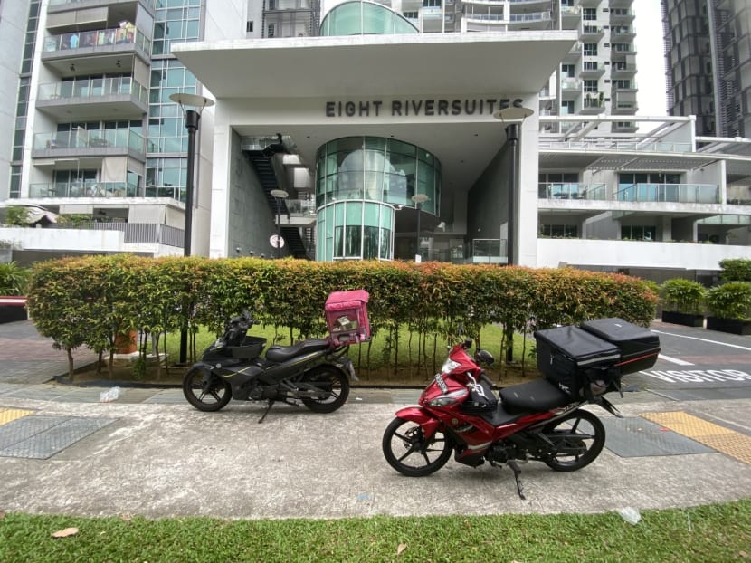 Two food delivery vehicles parked outside Eight Riversuites condominium on April 25, 2023.