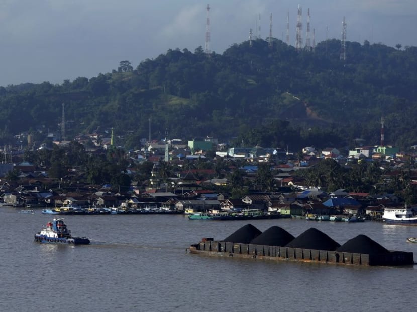 A tug boat pulls a coal barge along the Mahakam River in Samarinda, East Kalimantan province, Indonesia. A tug boat pulls a coal barge along the Mahakam River in Samarinda, East Kalimantan province, Indonesia.