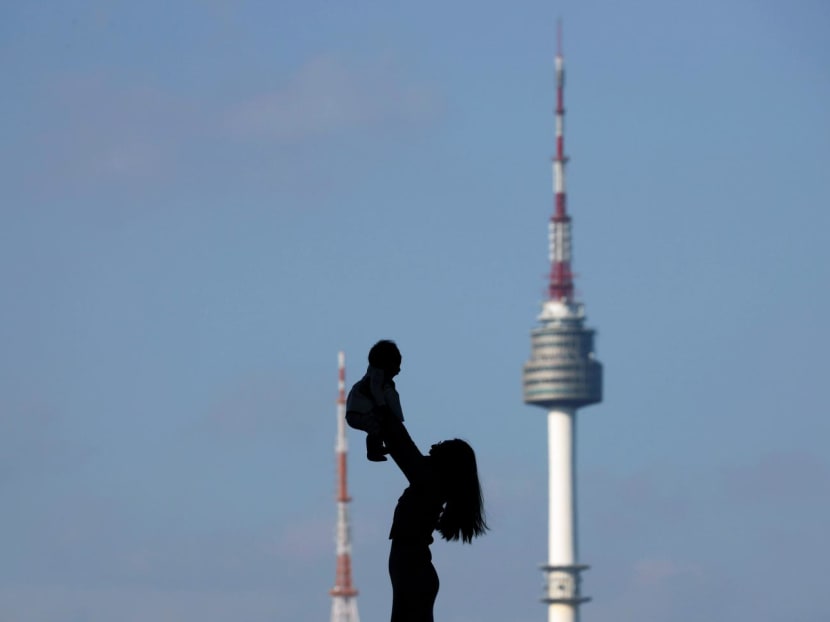 A woman holding up her baby is silhouetted against the backdrop of N Seoul Tower, commonly known as Namsan Tower, in Seoul, South Korea, Oct 2, 2018. A woman holding up her baby is silhouetted against the backdrop of N Seoul Tower, commonly known as Namsan Tower, in Seoul, South Korea, Oct 2, 2018.