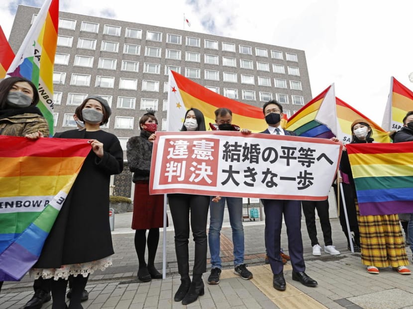 Plaintiffs' lawyers and supporters show a banner that reads 'Unconstitutional decision' after a district court ruled on the legality of same-sex marriages outside Sapporo district court in Sapporo, Hokkaido, northern Japan on March 17, 2021.