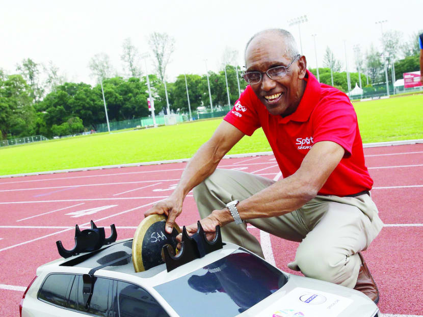 SA vice-president C Kunalan placing a discus on a remote-controlled, 1:5-scaled version of the Volvo XC90. The car will be used to shuttle the javelin, hammer and discus from the landing points in the field back to the start area. Photo: Ernest Chua