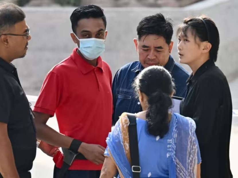 Asvain Pachan Pillai Sukumaran (in red), who is accused of murder after a brawl that left one man dead, was taken back on Aug 27, 2023 to the crime scene at Concorde Hotel and Shopping Mall along Orchard Road.