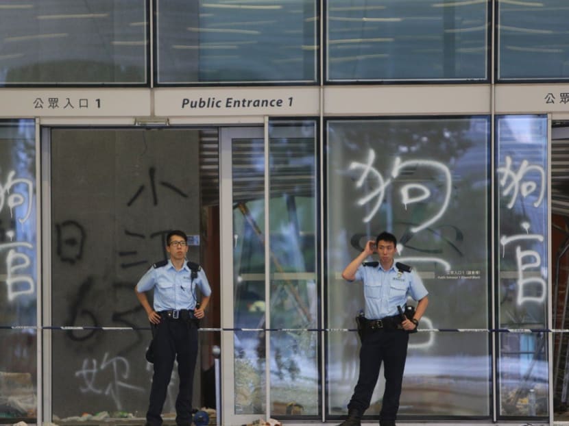 Police officers stand guard at the entrance to Hong Kong's Legislative Council after protesters stormed into it on Monday (July 1).