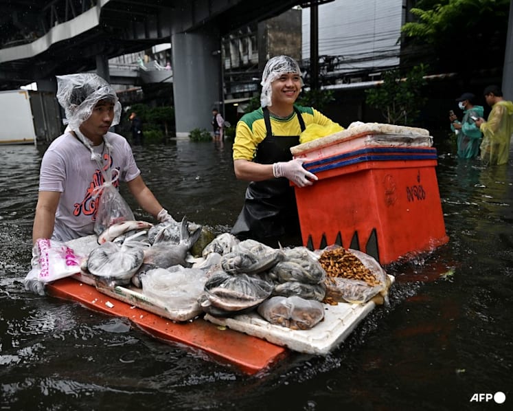 In kayaks or waist-deep in floodwater, shoppers return to Bangkok markets