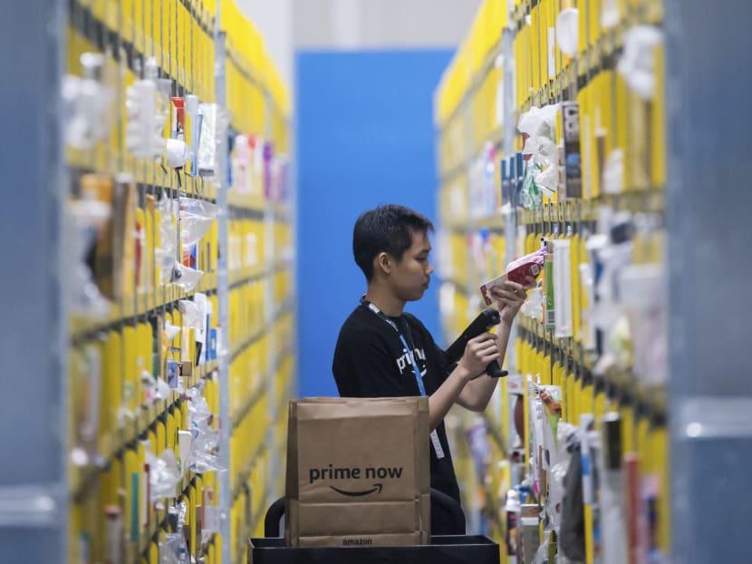 An employee scanning a product at the Amazon Prime Now facility in Singapore. Amazon has waived membership fees to the service to make it more attractive to shoppers in the Republic. Photo: AP