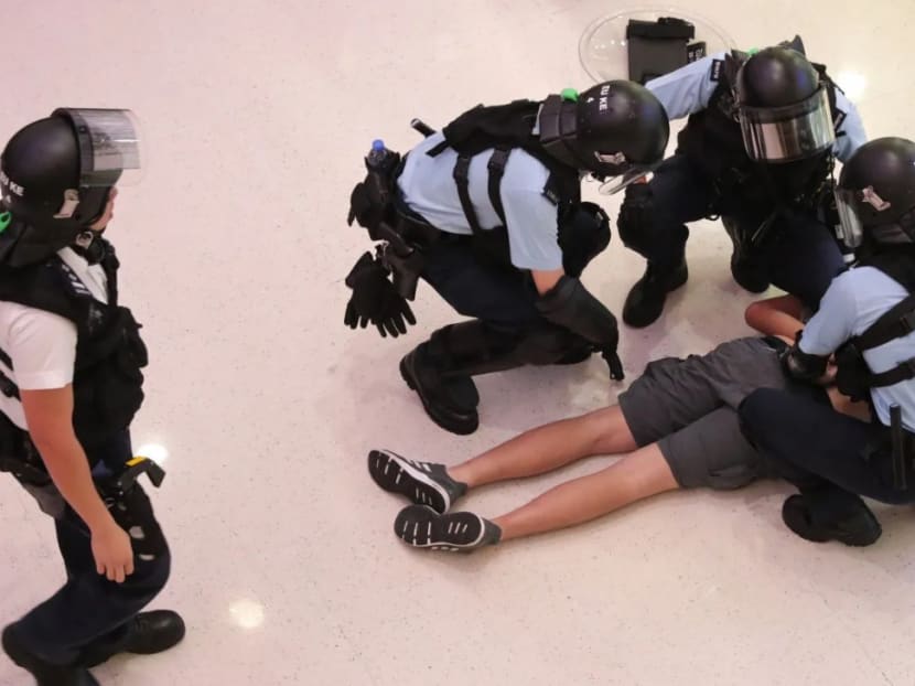 Police with a suspect at Amoy Plaza in Kowloon Bay.