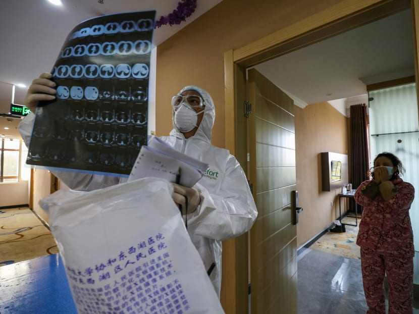 This photo taken on Feb 3, 2020 shows a doctor looking at a lung CT image while making his rounds at a ward of a quarantine zone in Wuhan of China's central Hubei province.