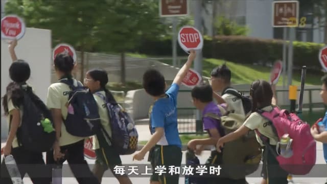 学生过马路举牌提醒司机 学生和家长：更容易引注意