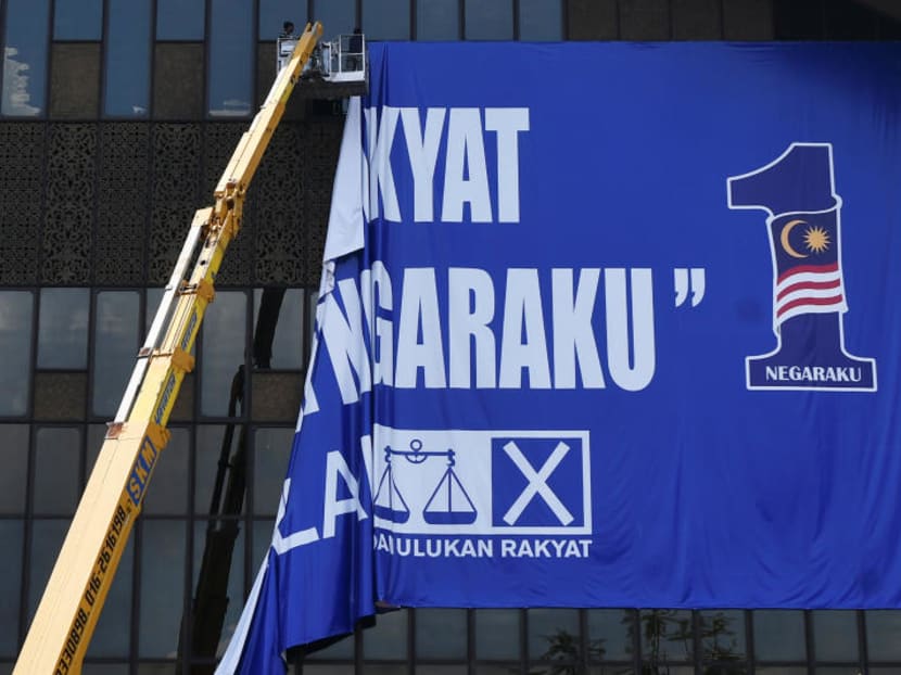 A worker tears down a Barisan Nasional flag at Putra World Trade Centre (PWTC) in Kuala Lumpur, Malaysia on May 10, 2018. A worker tears down a Barisan Nasional flag at Putra World Trade Centre (PWTC) in Kuala Lumpur, Malaysia on May 10, 2018.