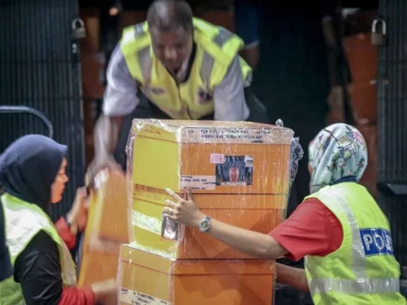 File picture of investigators lifting sealed boxes believed to contain luxury designer bags onto a Black Maria outside Pavilion Residences in Kuala Lumpur on May 18, 2018.