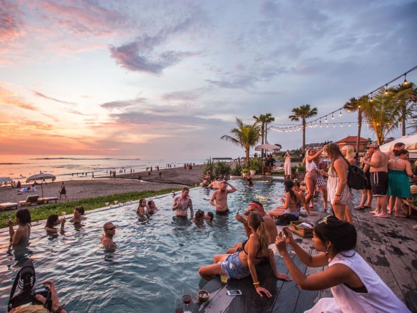 Tourists at The Lawn in Canggu, Bali in Indonesia. People are likely to act more hedonistically while on holiday, says the author.