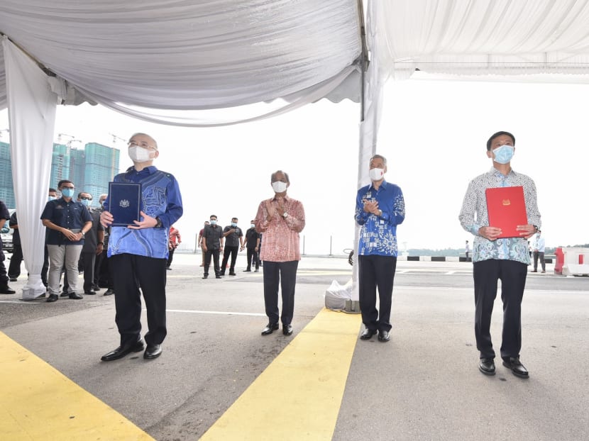 Singapore’s Transport Minister Ong Ye Kung (right) and his Malaysian counterpart Wee Ka Siong (left) signed the official agreement to resume the project on July 30, 2020, at a ceremony witnessed by Prime Minister Lee Hsien Loong (second from right) and Malaysian premier Muhyiddin Yassin (second from left).