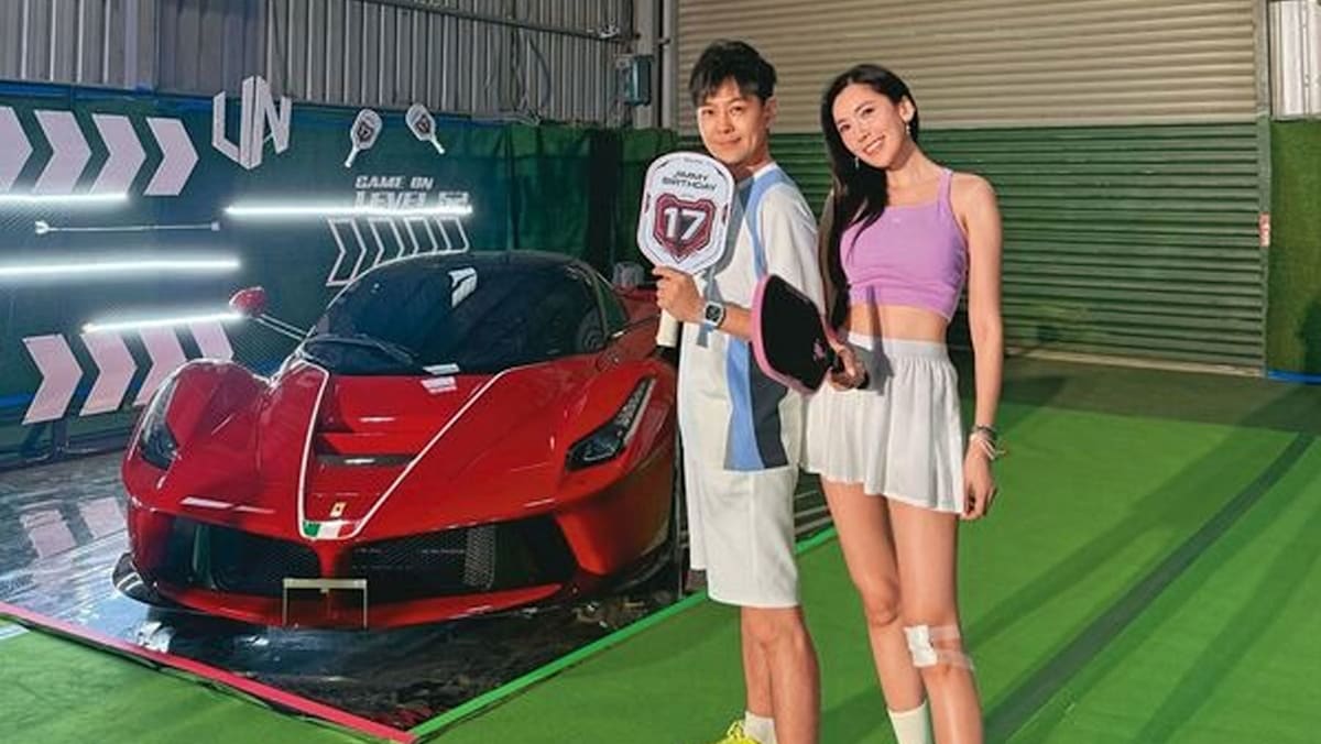 赤いFerrari F80の前で、誕生日のボードを持つ林志穎と女性