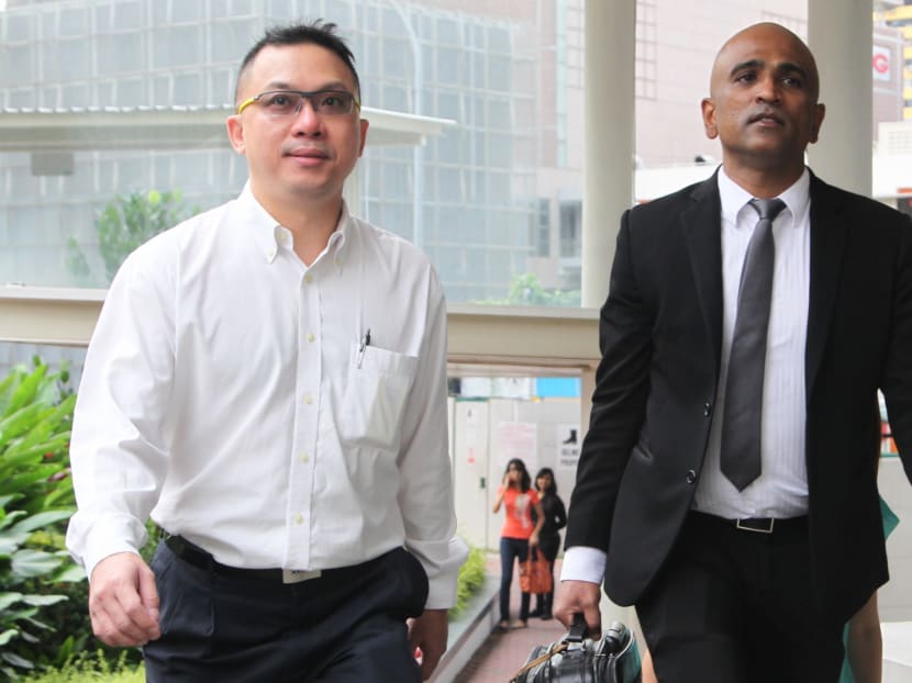 Delson Moo, charged with defacing the Istana website arriving at the Subordinate Courts with his lawyer M Ravi.