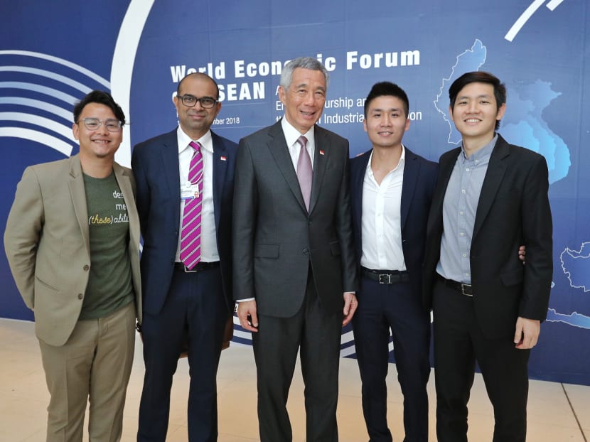 Prime Minister Lee Hsien Loong (centre) and Senior Minister of State (Transport, and Communications and Information) Janil Puthucheary (second from left) meeting some young Singaporeans who are in Hanoi as part of the Global Shapers network.