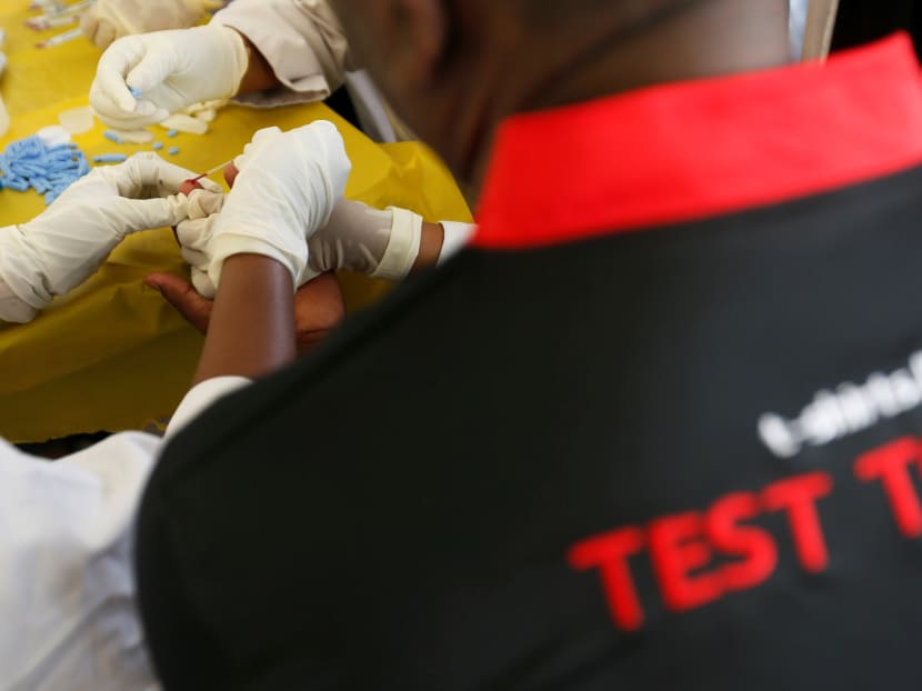 A nurse takes blood from a man who received a free HIV test at an event to mark World Aids Day.