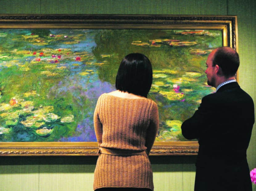 Auction house Christie’s employees examine Claude Monet’s water lily painting 
Le Bassin aux Nympheas in New York. Photo: Reuters