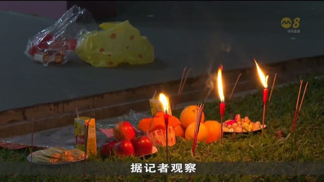 民众在农历七月初一焚烧冥纸 结束后现场散落冥纸和香烛供品