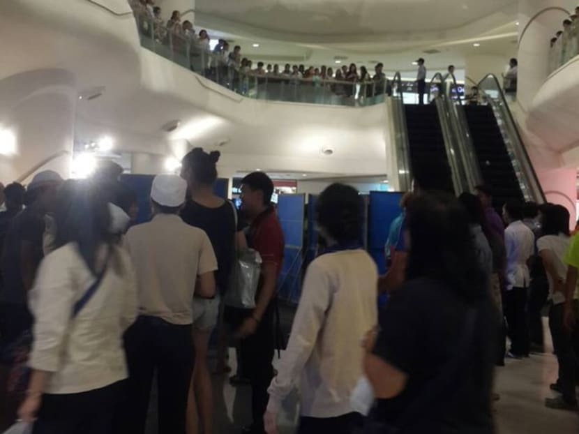 Shoppers gather around the body of the deceased at the Silom Complex shopping mall. Photo: JS100/Twitter