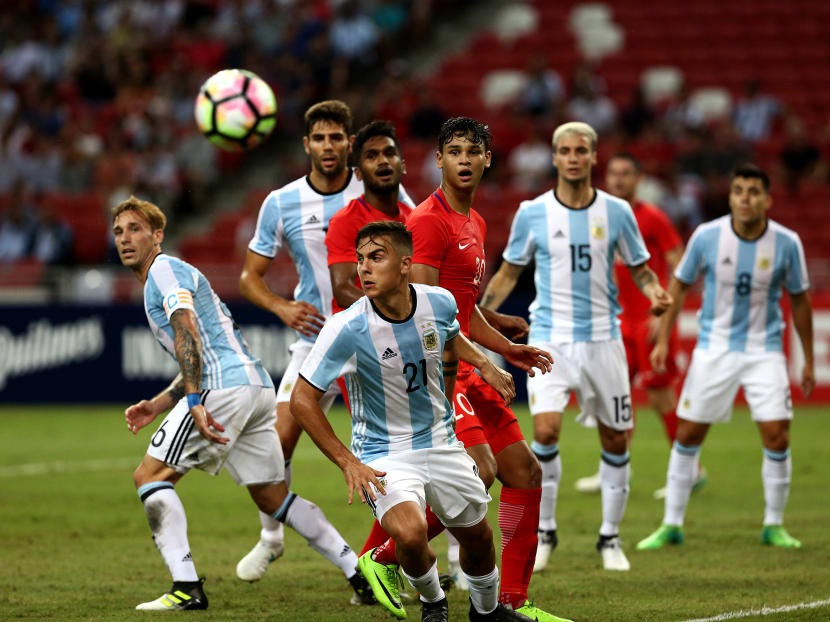 Argentina's Paulo Dybala (centre, front) turns as Singapore players Hariss Harun (in red, left) and Irfan Fandi look on during the friendly match between Argentina and Singapore, held at the National Stadium on June 13, 2017. Photo: Nuria Ling/TODAY