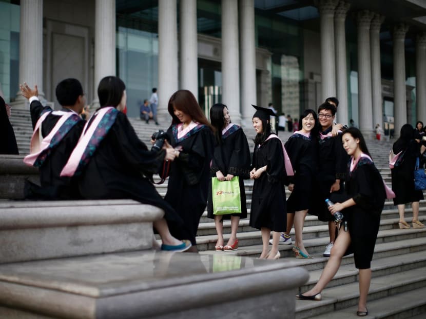 Graduates stand on the steps in front of the academic building at Fudan University in Shanghai. Graduates stand on the steps in front of the academic building at Fudan University in Shanghai.