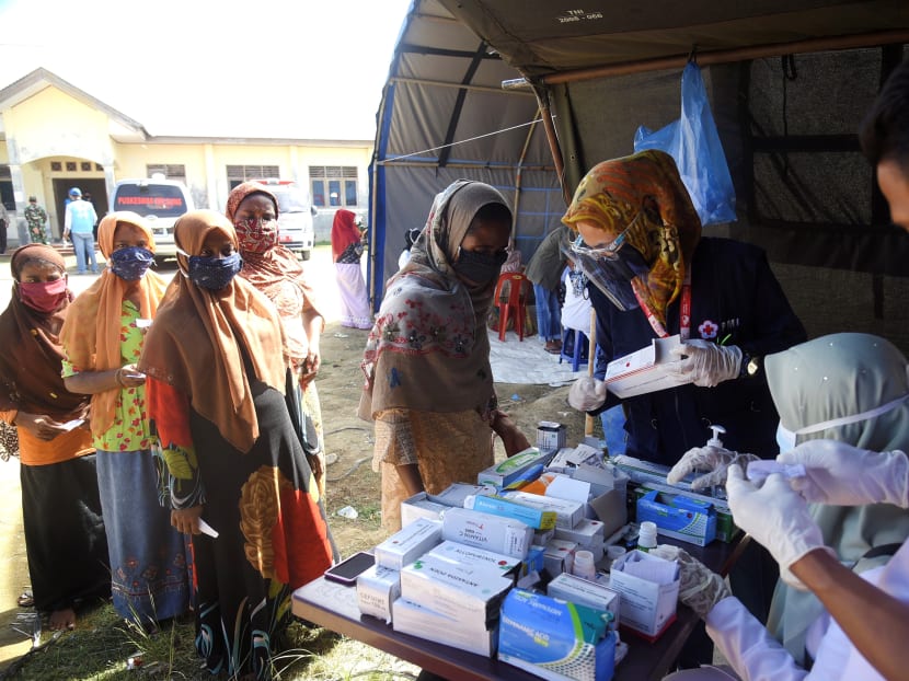 This picture taken on Sept 9, 2020 shows a group of Rohingya women queueing up for medical check-ups at a transit camp after nearly 300 Rohingya migrants came ashore on the beach in Lhokseumawe on the northern coast of Indonesia's Sumatra island.