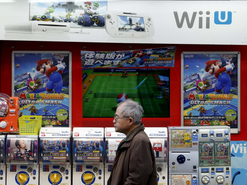 A man stands in front of an advertisement board of Nintendo's Wii U game console software outside an electronics retail store in Tokyo, Japan, Feb 2, 2016. Photo: Reuters