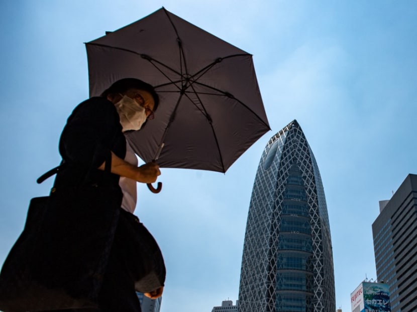A pedestrian walks with an umbrella to shield from the sun amid a heatwave in Tokyo's Shinjuku district on June 28, 2022. A pedestrian walks with an umbrella to shield from the sun amid a heatwave in Tokyo's Shinjuku district on June 28, 2022.