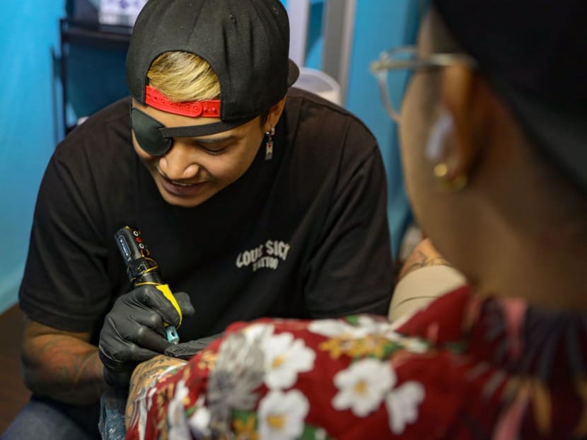 Tattoo artist Mohamed Tirana Mohamed Sufian working on a tattoo in his studio at Parklane Shopping Mall on Sept 16, 2024. 