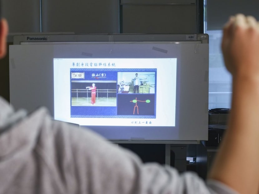 Students learn Chinese opera by following a video demonstration.