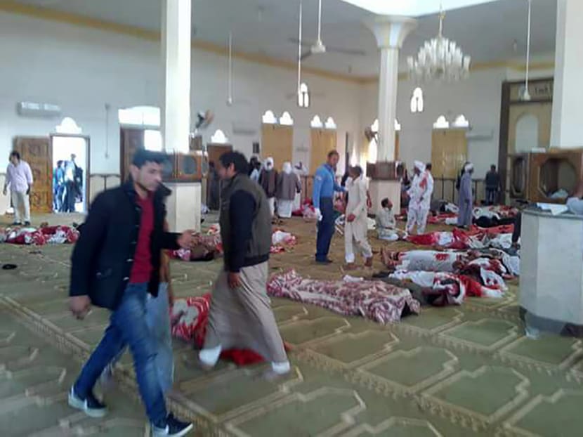 Egyptians walk past bodies following a gun and bombing attack at the Rawda mosque. A bomb explosion ripped through the mosque before gunmen opened fire on the worshippers. Photo: AFP Egyptians walk past bodies following a gun and bombing attack at the Rawda mosque. A bomb explosion ripped through the mosque before gunmen opened fire on the worshippers. Photo: AFP