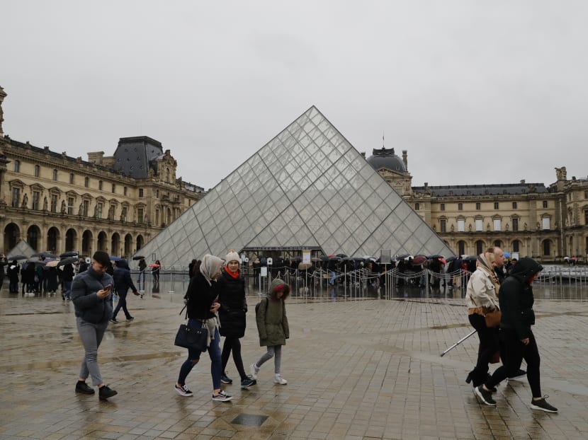 People wait in front of the Louvre museum in Paris on March 1, 2020. An informational meeting on the public health situation linked to Covid-19 prevention measures has delayed the opening of the museum on March 1, 2020.