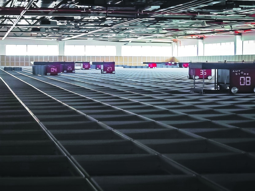 The warehouse management system, called Autostore, involves 36 robots plying the top of the grid to store and extract products. Photo: DHL