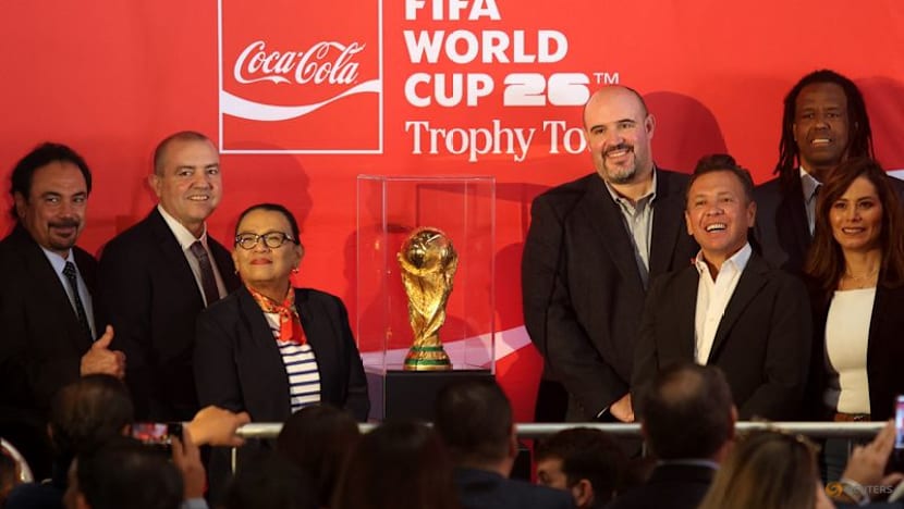 Mexican fans enjoy a brief respite from violence as they gaze at World Cup trophy