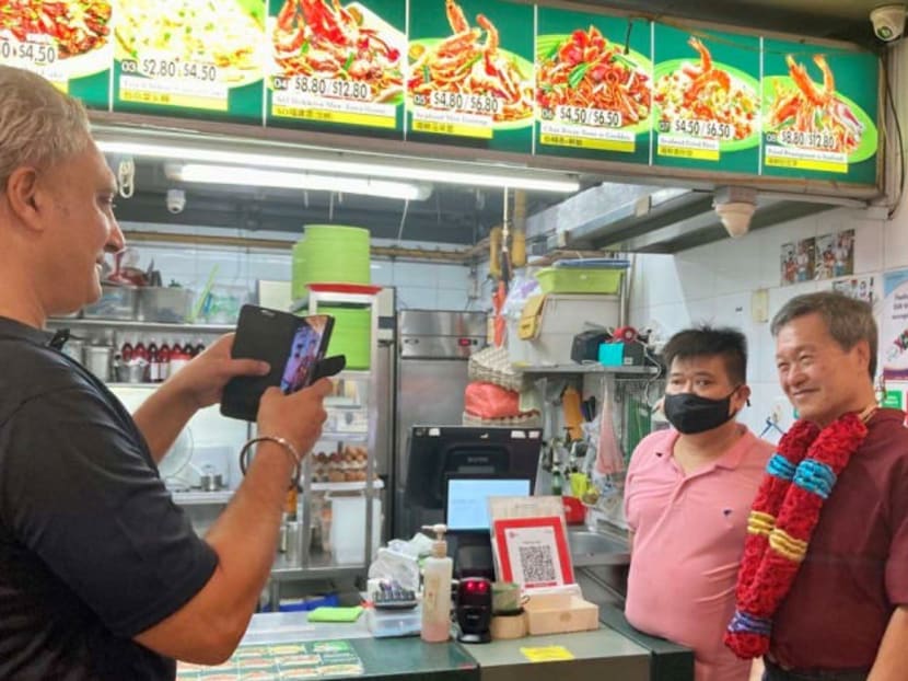 Presidential hopeful Tan Kin Lian poses for a picture with a hawker at Hawker Centre @ Our Tampines Hub on Aug 12, 2023. 