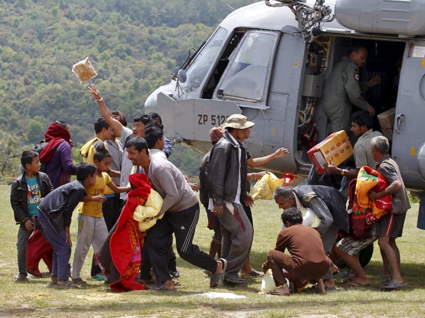 People collect relief material supplied by an Indian Air Force helicopter in a village affected by Saturday's earthquake at Pokhara, Nepal, May 1, 2015. Photo: Reuters