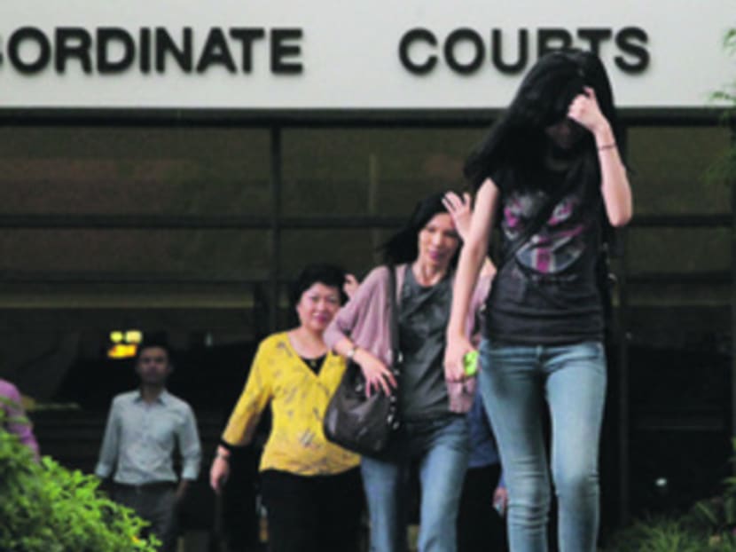Family of deceased taxi driver, daughter Stephanie Cheng and widow Lim Choo Eng, leaving the sub courts yesterday. Photo by DON WONG