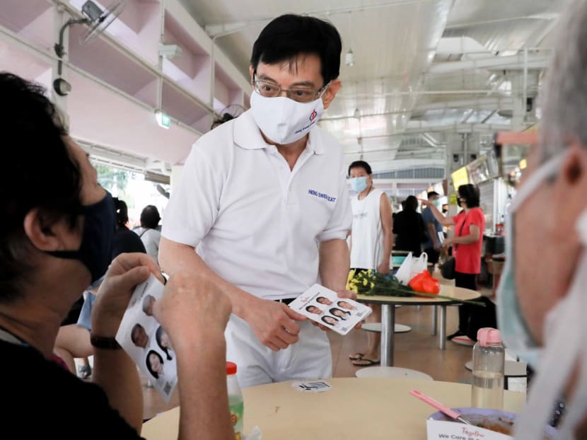 Mr Heng Swee Keat from the People’s Action Party speaks to a resident during a walkabout at Block 216 Bedok Food Centre and Market on Friday, July 3, 2020.