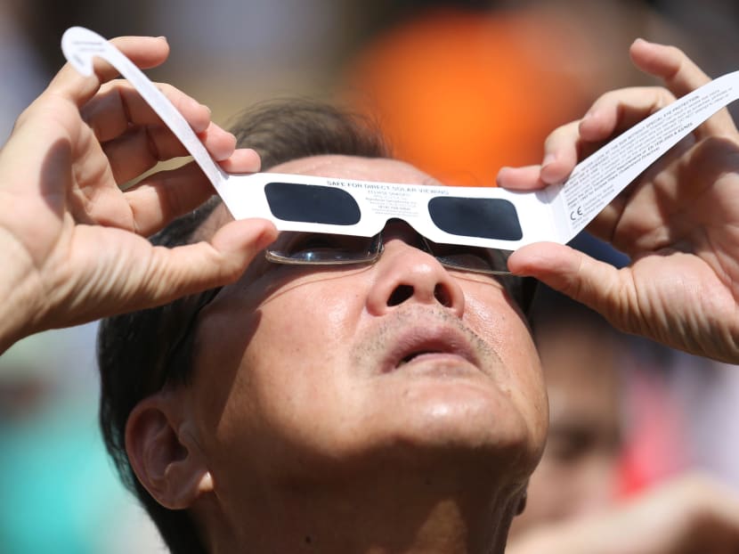 A man viewing the annual solar eclipse with protective glasses at Kebun Baru Spring Amphitheatre on Thursday (Dec 26) where more than 1,000 viewers gathered. A man viewing the annual solar eclipse with protective glasses at Kebun Baru Spring Amphitheatre on Thursday (Dec 26) where more than 1,000 viewers gathered.