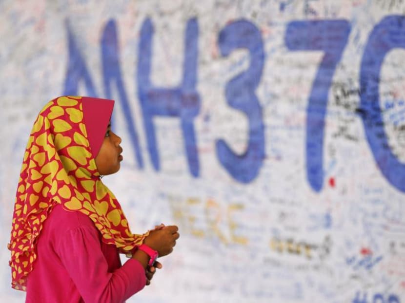 A girl looks at a board with messages of support and hope for passengers of the missing Malaysia Airlines MH370. Photo: Reuters