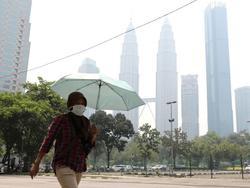 A woman wears a mask as the Petronas Twin Towers are shrouded in haze in Kuala Lumpur, Sept 11, 2019. A woman wears a mask as the Petronas Twin Towers are shrouded in haze in Kuala Lumpur, Sept 11, 2019.