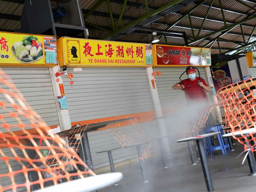 A cleaning worker is seen washing the tables at 115 Bukit Merah View Market and Food Centre on June 14, 2021 after a Covid-19 cluster emerged there.