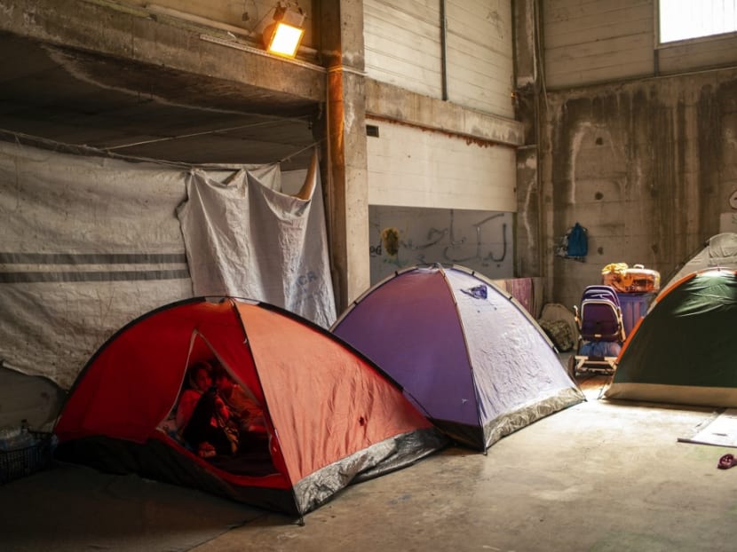 Two girls sit in their tent in an abandoned building near the Kara Tepe camp, on the Greek Aegean island of Lesbos on Sept 16, 2020, after the Moria migrant camp was destroyed by a fire on the night of Sept 8.