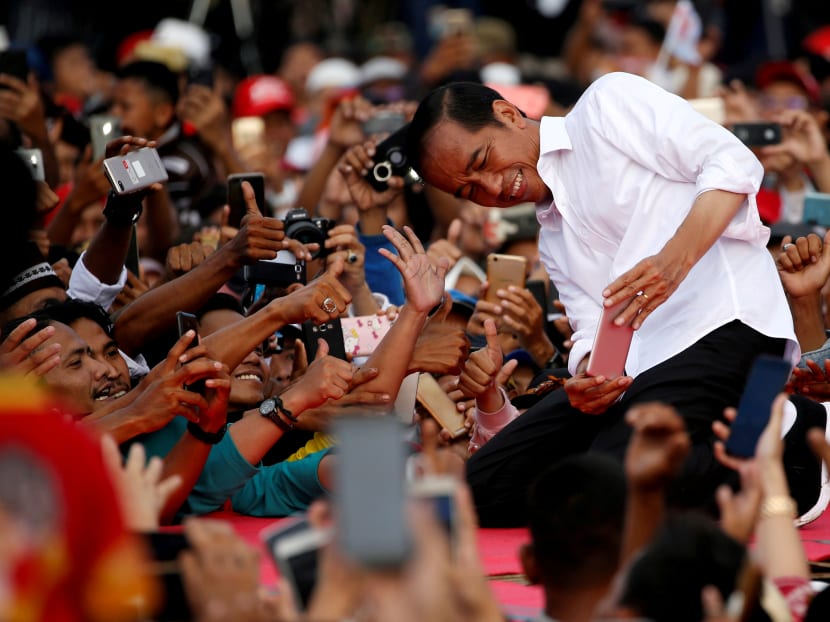 Indonesia's presidential candidate for the upcoming general election Joko Widodo takes pictures with his supporters.