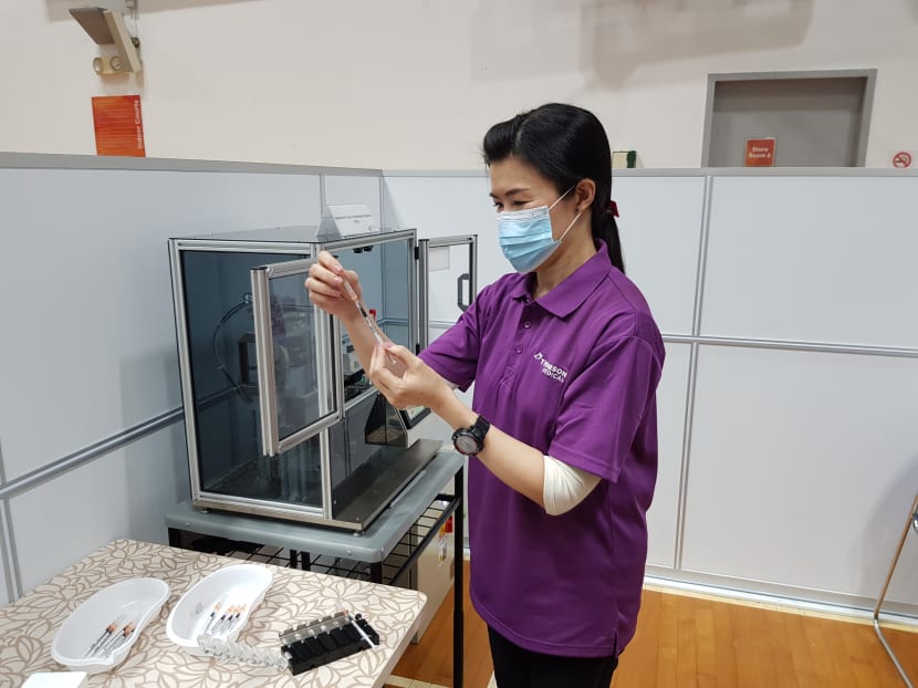 A nurse is seen using a vaccine dispenser which was designed and developed to address the labour-intensive steps of the vaccination process.