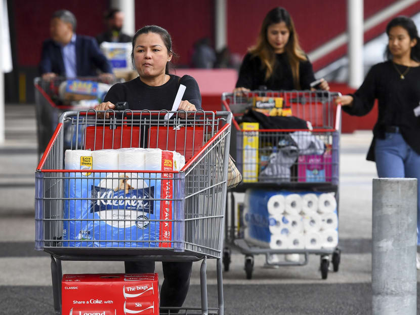 People leave a Costco warehouse in Melbourne with rolls of toilet paper among their groceries on March 5, 2020. People leave a Costco warehouse in Melbourne with rolls of toilet paper among their groceries on March 5, 2020.