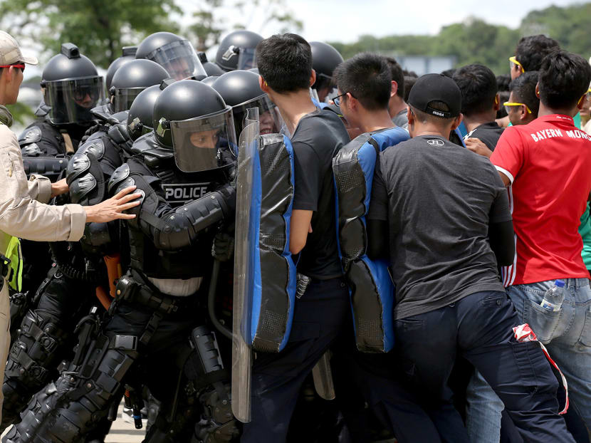 Members of the media, wearing Public Order protective gear, use their shields to block "rioters", as part of an experience being part of the Police Tactical Unit that took place at the Home Team Tactical Centre on Oct 12, 2018.